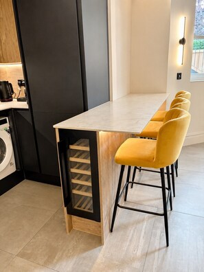 Een moderne keuken met een inbouw eiland, een wasmachine en een koffiezetapparaat.