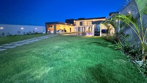 Une maison moderne avec une pelouse bien entretenue et une allée pavée.