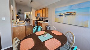 A dining area with a round table, chairs, and a painting of boats on the wall. - Relax & Play Dallas Home Sleeps 10 Near Parks & Attractions (Dallas)