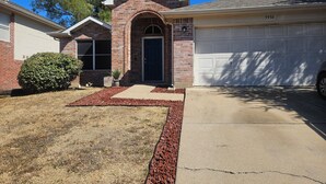 A two-story house with a brick facade, a front entrance with a door, and a garage. - Relax & Play Dallas Home Sleeps 10 Near Parks & Attractions (Dallas)