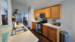 A kitchen with wooden cabinets, a stainless steel stove, a microwave, and a sink. - Relax & Play Dallas Home Sleeps 10 Near Parks & Attractions (Dallas)