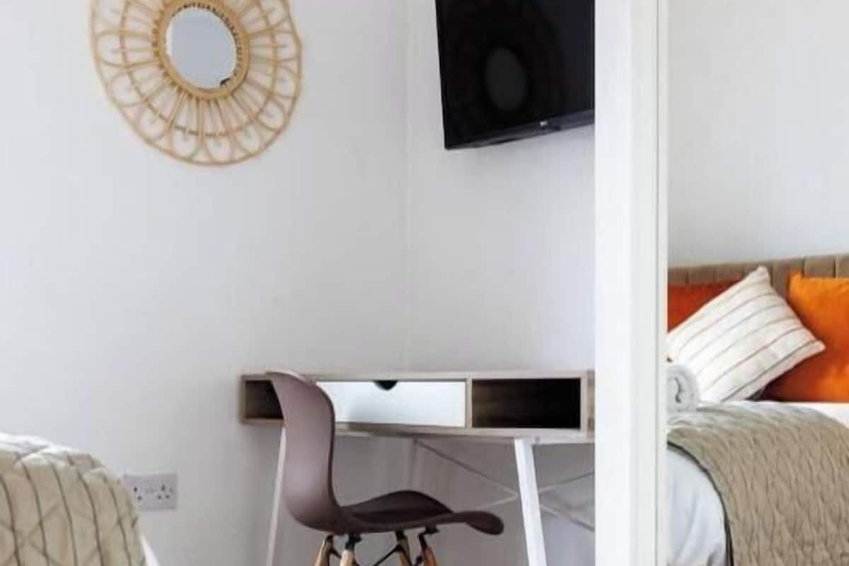 A modern bedroom with a bed, a desk, and a chair.