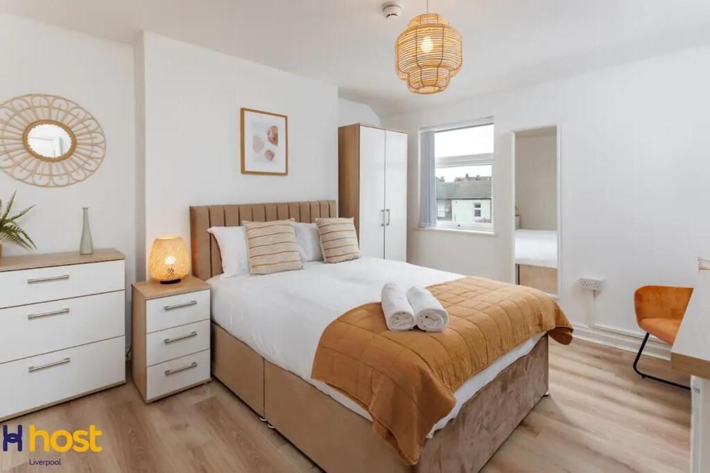 A modern bedroom with a bed, bedside table, lamp, and wardrobe.