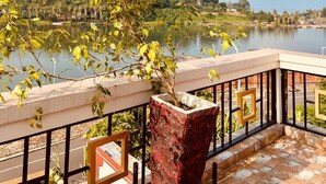 A balcony with a view of a lake and distant hills.