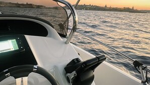A boat's steering wheel and dashboard with a view of the water and a sunset in the background. - Apartment 6 - El Classico Apartments (Rubavu)