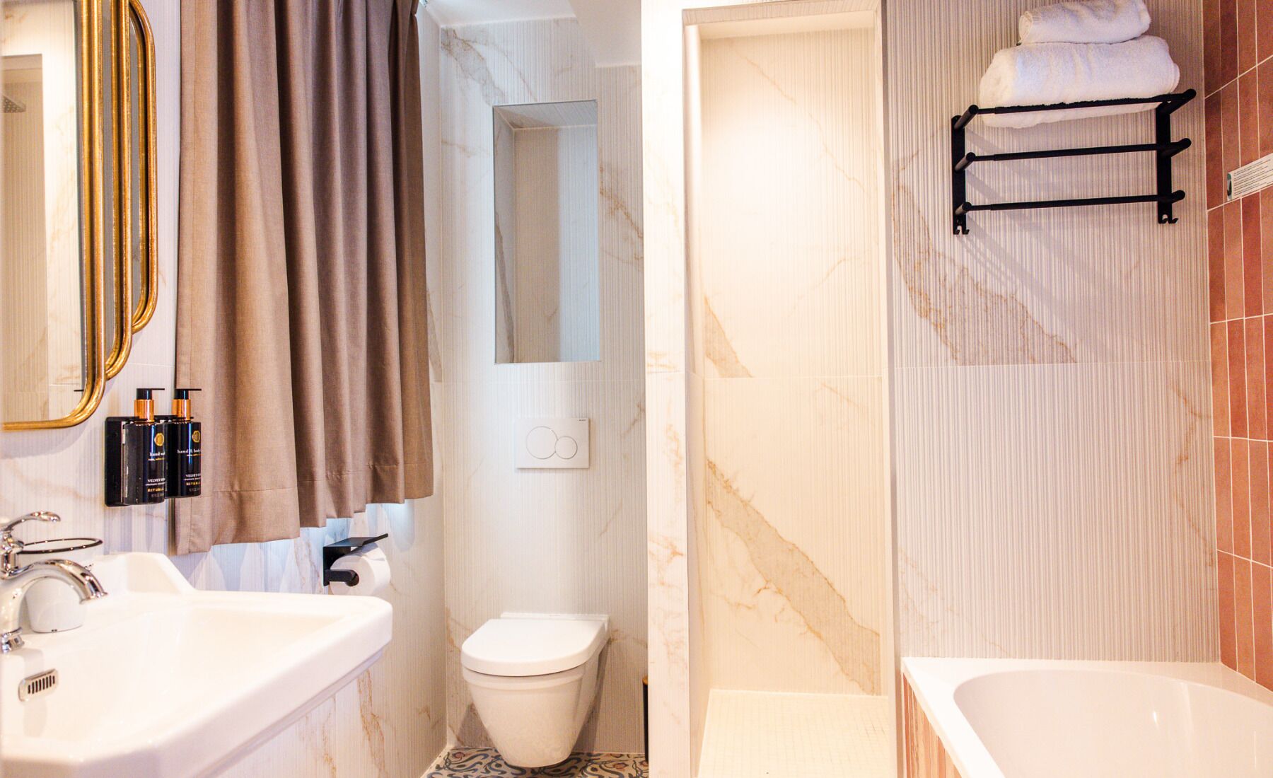 Un baño con lavamanos, inodoro y bañera.