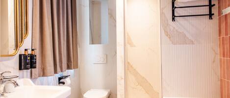 Un baño con lavamanos, inodoro y bañera.
