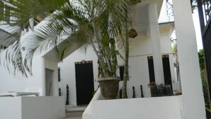 A staircase leading to a building with white walls and black doors. - Steps from the beach - easy checkin (Brisas de Zicatela)