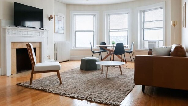 Ein modernes Wohnzimmer mit Kamin, Fernseher und Essbereich mit Tisch und Stühlen.