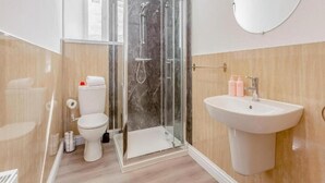 Une salle de bain moderne avec une douche à parois de verre, des toilettes et un lavabo.