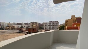 A balcony with a clear view of the surrounding buildings and a partly cloudy sky. - Welcome to your peaceful retreat in the heart of Al Ahyaa, Hurghada. (Hurghada)