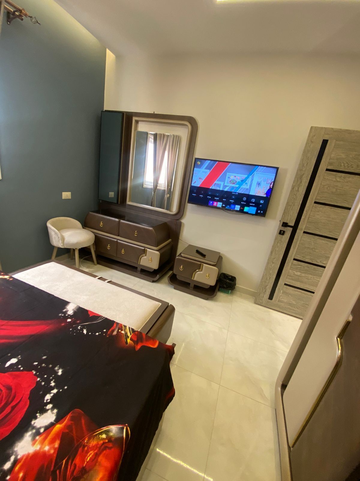 Een hotelkamer met een bed, een dressoir, een televisie en een kledingkast.