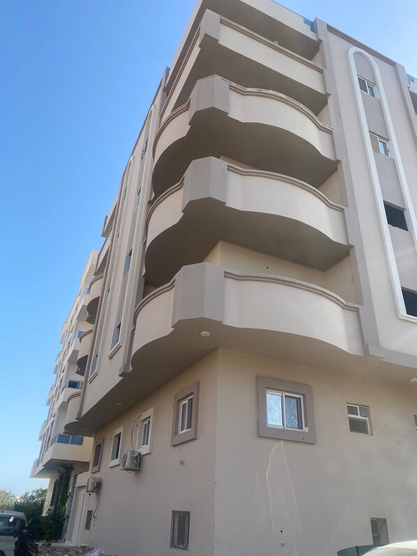A multi-story building with balconies and windows. - Spacious 3-bedroom apartment in soothing Hurghada with AC (Hurghada)