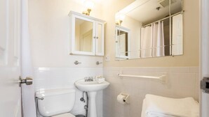 Une salle de bain avec des toilettes, un lavabo et des serviettes pliées.
