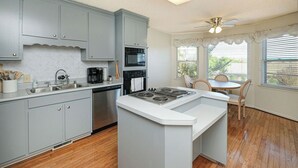 A kitchen with grey cabinets, a built-in stove, and a dining area with a table and chairs. - large Stunning Retreat 15 min to Downtown Huntsville 3br/3bath (Huntsville)