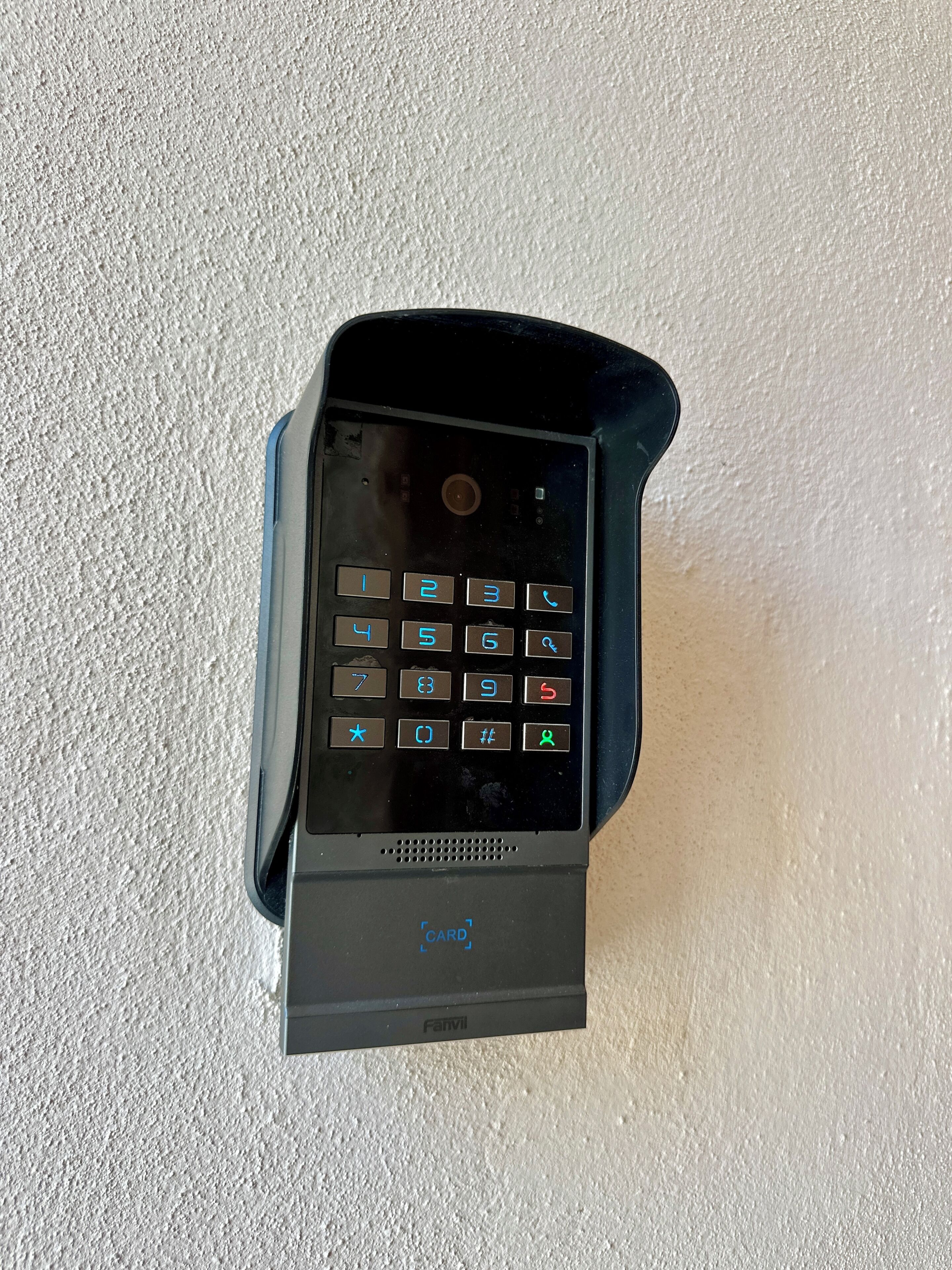 A black card reader with a keypad, placed on a textured surface.