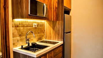 Departamento Deluxe, vista al mar | Cocina privada | Refrigerador, microondas, parrilla de estufa y utensilios de cocina