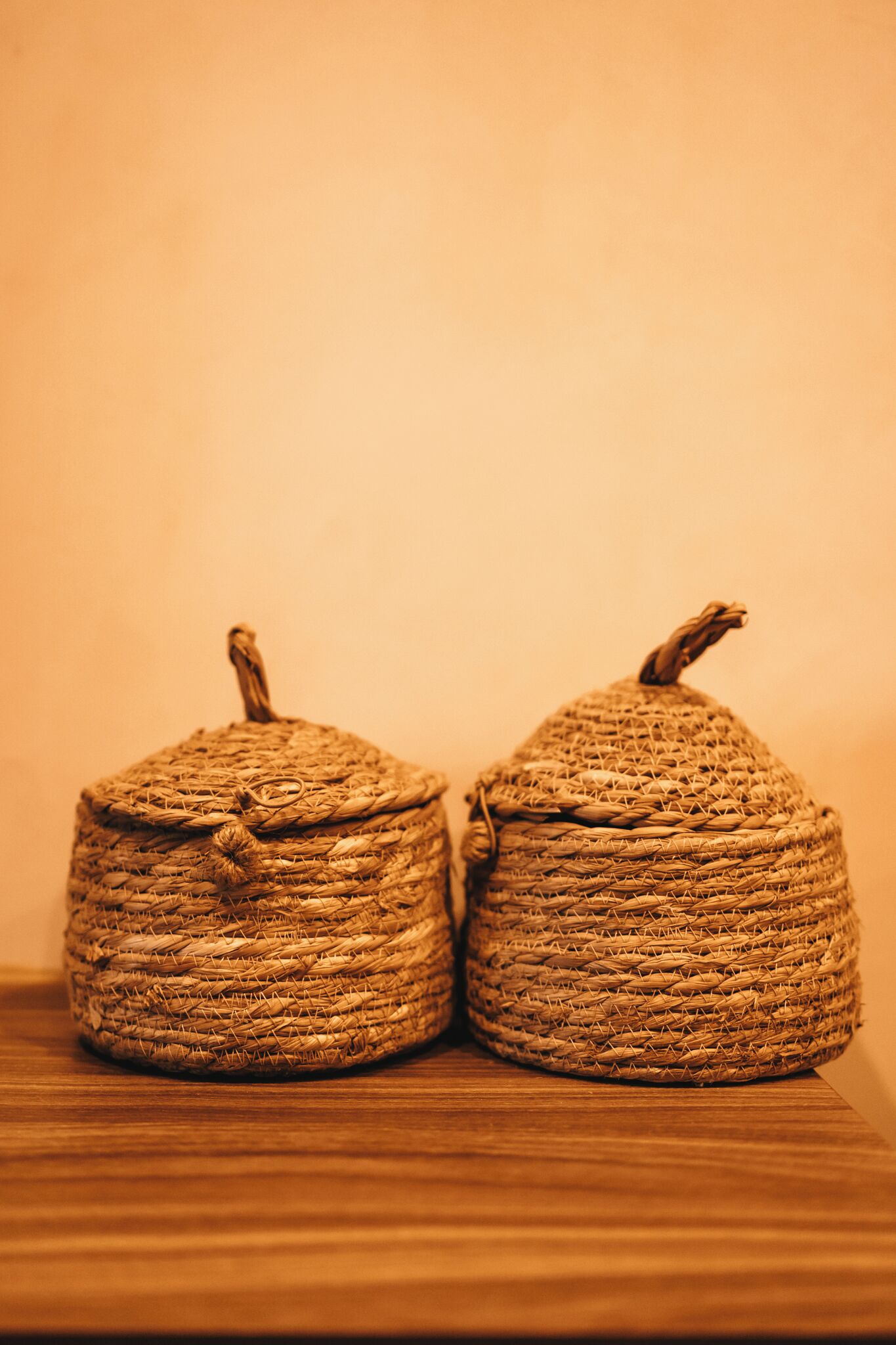 Two woven baskets on a wooden surface.