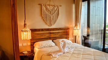 Ein Hotelzimmer mit einem hölzernen Kopfteil, einer Wanddekoration aus Makramee und einem Bett mit weißer Bettdecke.