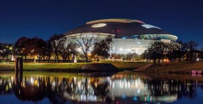 A stadium with a large circular roof and a reflection in the water in front. - Full Family Stay Near At&t, Ballpark, 6 Flags & Airport (Grand Prairie)