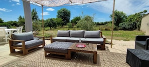 An outdoor patio with a wooden table, two chairs, a sofa, and a pergola. - Charming country house retreat with swimming pool Douzillac (Douzillac)