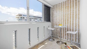 A modern room with a large window, a patterned wall, and a small table with a plant. - Condado del Mar by Otium (San Juan)