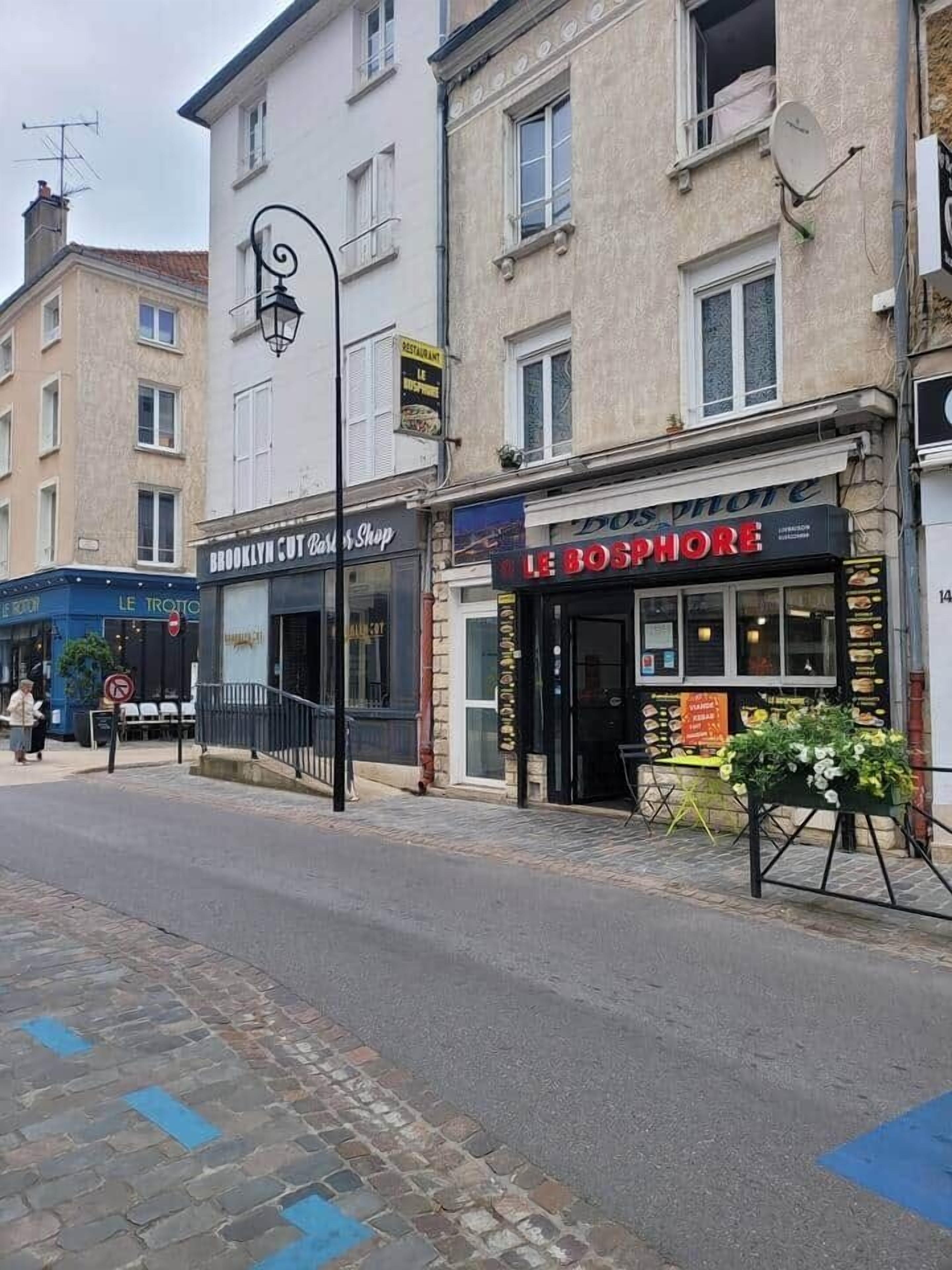 A street view with a restaurant named 'Le Bosphore' and a shop called 'Brooklyn Cut & Shop'.