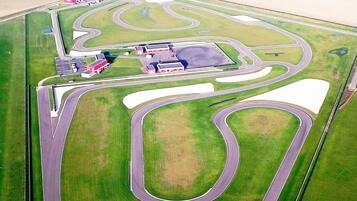 Une vue aérienne d’un circuit automobile comportant plusieurs pistes, une zone d’arrêt et un grand parking.