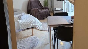 A hotel room with a bed, a chair, a desk, a television, and a window. - Quiet studio with optional access to a shared pool (La Ferté-Gaucher)