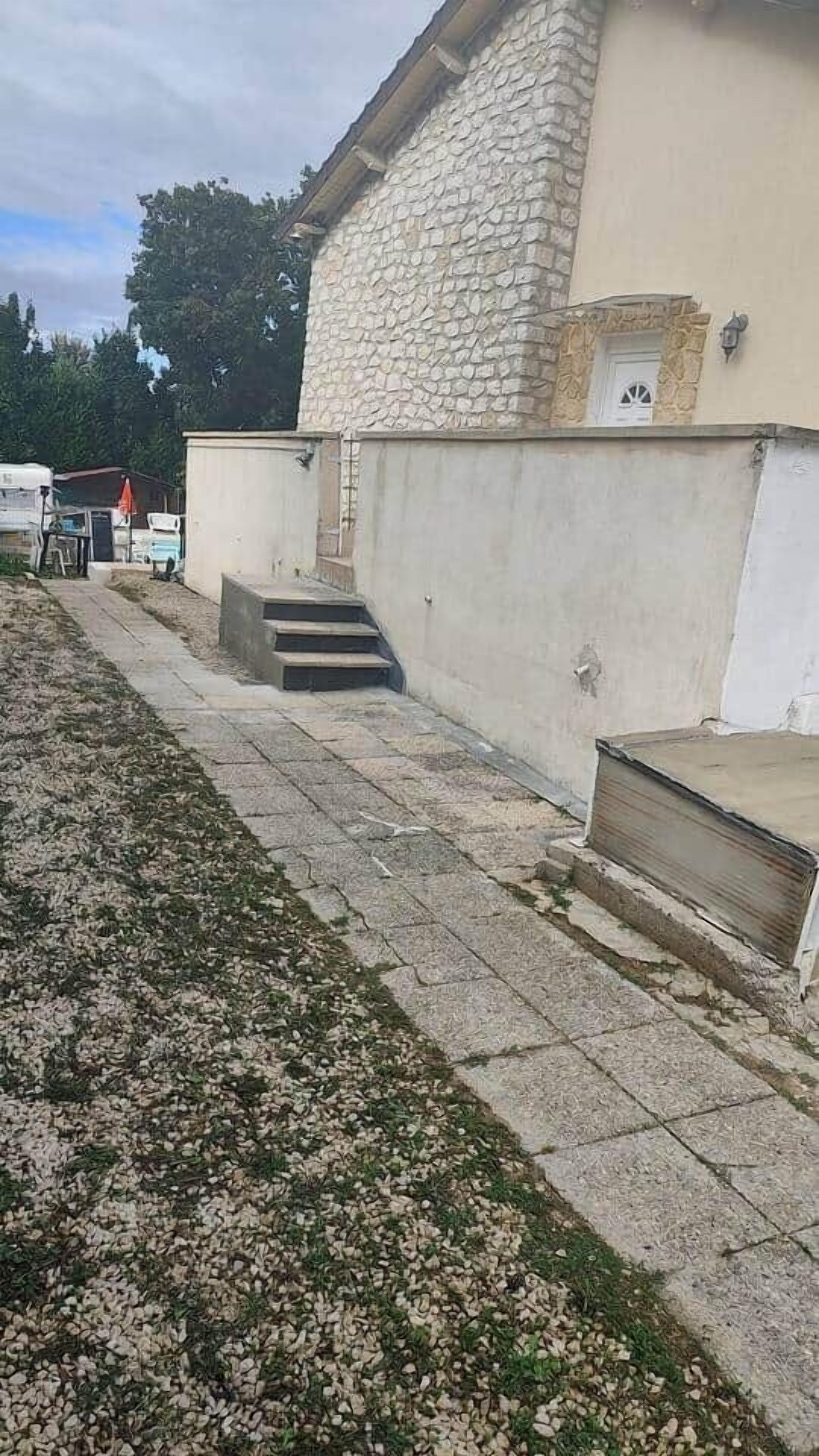 Un edificio de piedra con unos pocos escalones que conducen a una puerta.