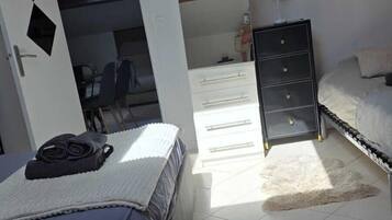 A bedroom with a bed, a dresser, a skylight, and a view of the sky.