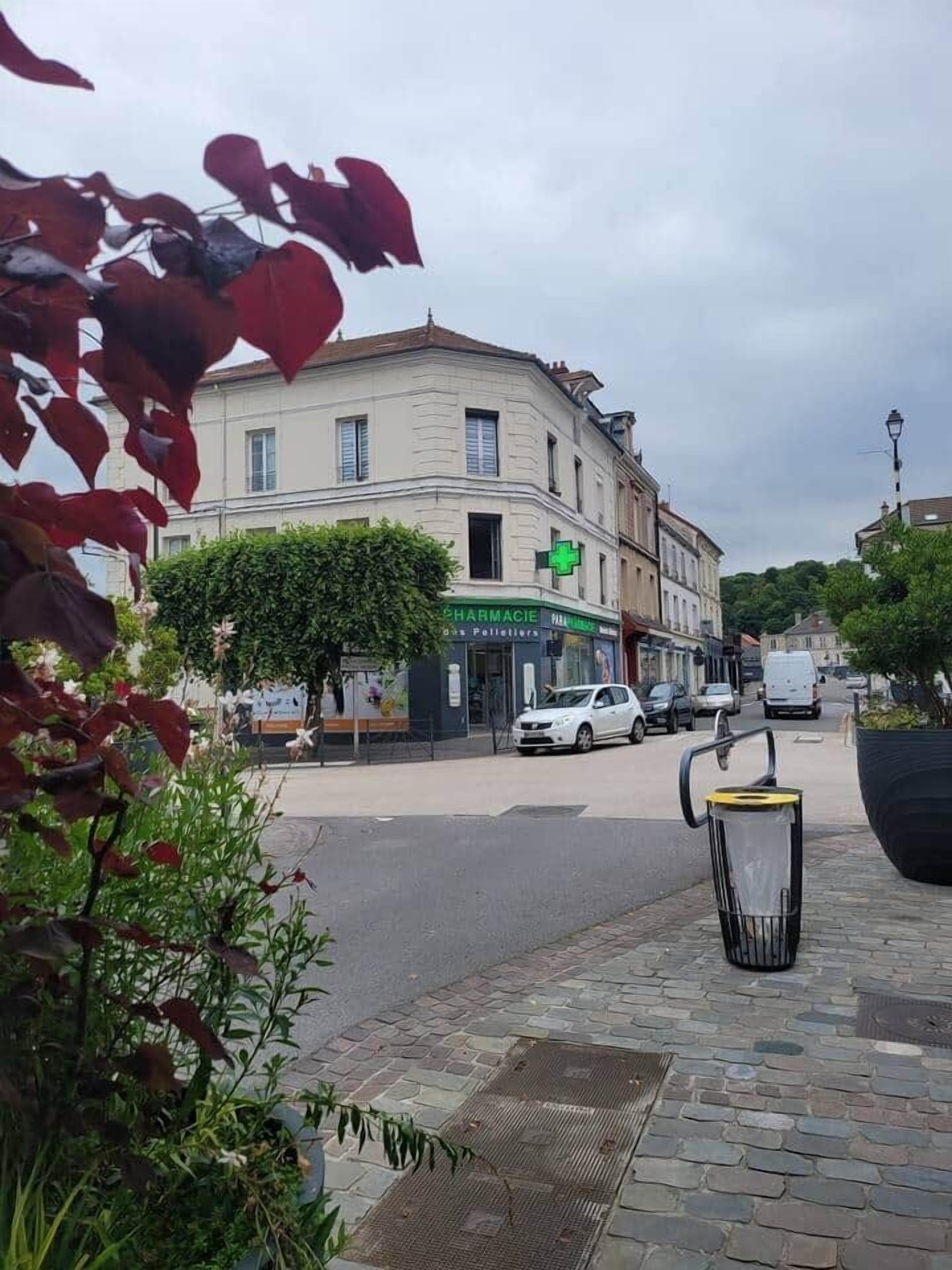 Ein Gebäude mit einer Apotheke, parkenden Autos und einer Straßenlaterne.