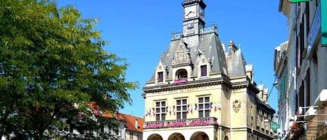A historic building with a clock tower, arched windows, and a sign for 'Mason de la Presse'.