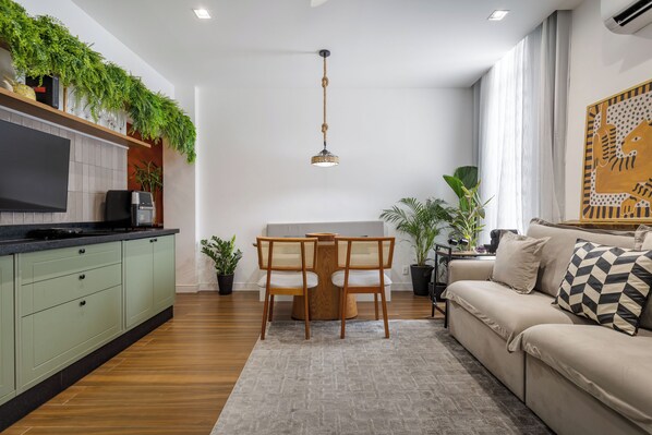 A modern kitchen with a dining area, a sofa, and a TV. - Sanci Mare: 1 bedroom and 2 bathrooms in Copacabana   (Rio de Janeiro)