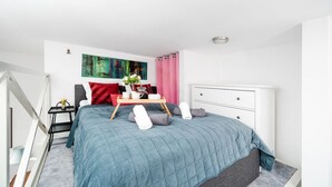 Ein modernes Schlafzimmer mit Bett, Nachttisch und einem Bild an der Wand.