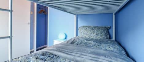 A room with a bed, a wardrobe, and a nightstand.