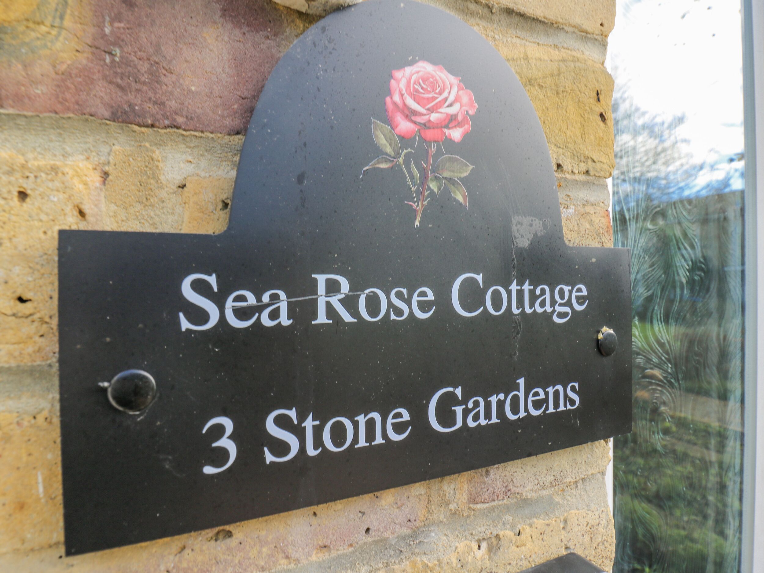 Un panneau indiquant l’emplacement de la maison de vacances « Sea Rose Cottage », située au 3, Stone Gardens.