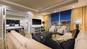 A modern hotel room with a sofa, armchairs, a TV, and a city view. - Wategate 1 Bed, 1 Bath Villa - Bookings only Monday - Friday or Friday - Monday (Las Vegas)