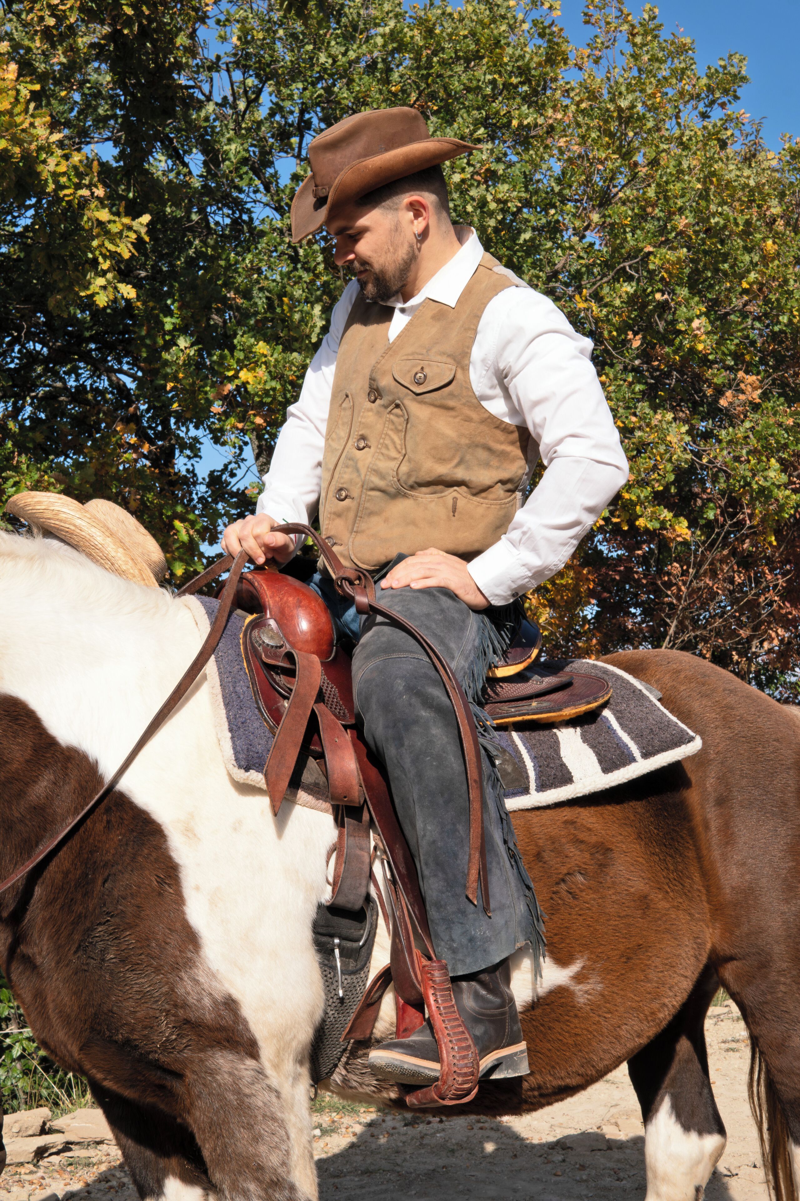 Une personne à cheval, équipée d’une selle et d’un mors.