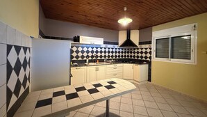 A kitchen with a checkered floor, wooden ceiling, and a window with blinds. - Large 100 m² T3 with garden & sea view - Absolute peace and quiet in Petite-Île (Petite-Île)