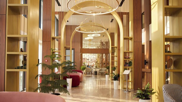 Eine großzügige Lobby mit einem polierten Marmorboden, Holzregalen und gemütlichen Sitzbereichen.