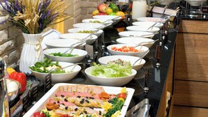 Ein reichhaltiges Buffet mit verschiedenen Speisen und einer Blumenvase.