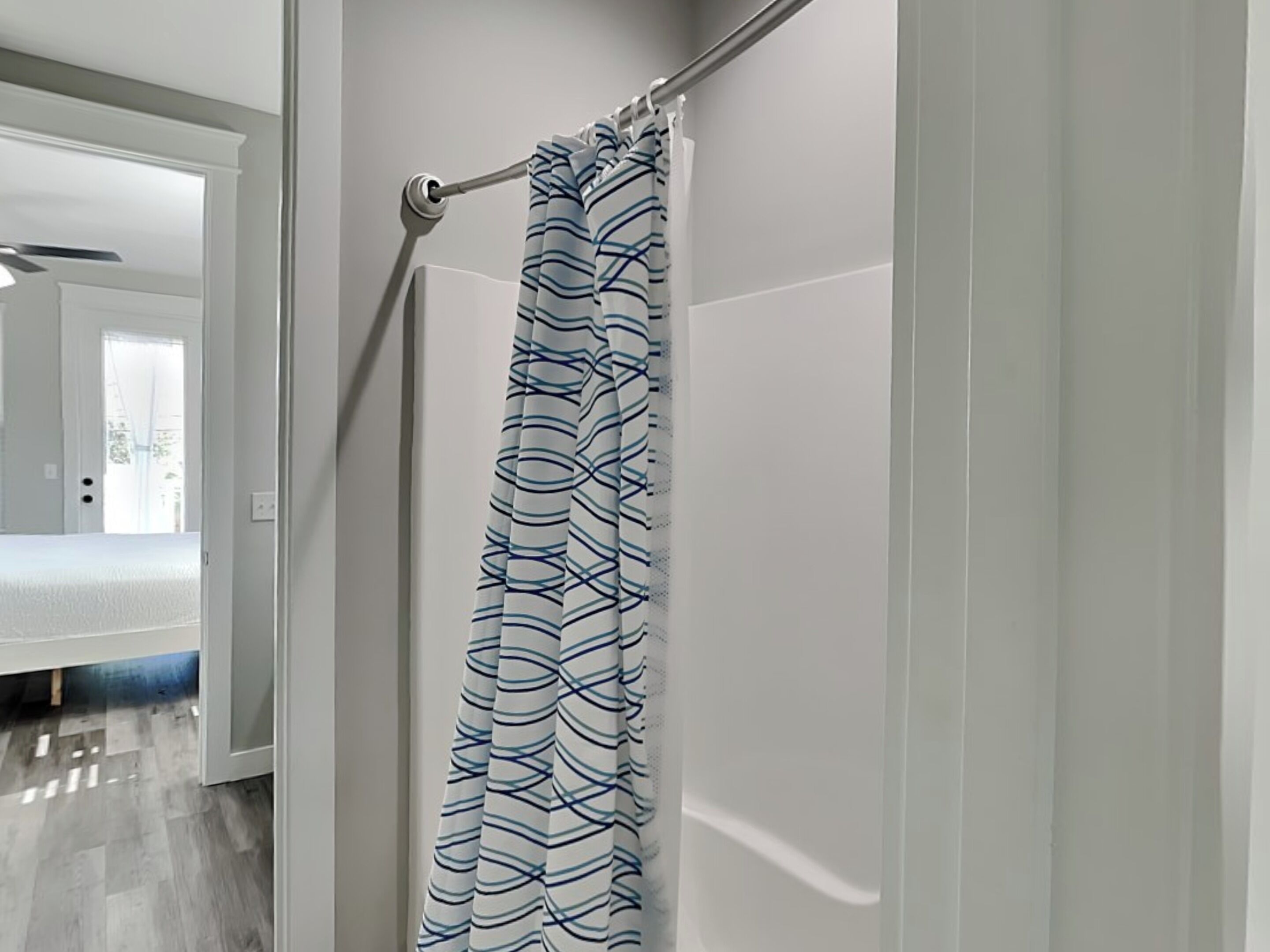 A bathroom with a shower curtain featuring a blue and white pattern.