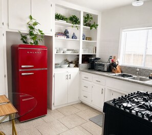 A kitchen with white cabinets, a red Galanz refrigerator, a gas stove, and a window with blinds. - Downtown Studio FREE Parking & 1 mile to Beach & Convention Center (Long Beach)