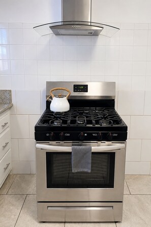 A stainless steel kitchen with a gas stove, oven, and a kettle on the stove. - Downtown Studio: Free On-Site Parking • One Mile to Beach & Convention Center (Long Beach)