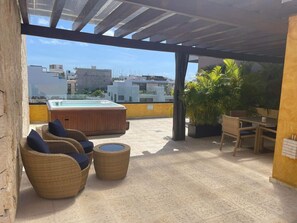 A rooftop terrace with wicker furniture, a hot tub, and a view of the cityscape. - Lunada. Modern-Quiet ! 2B 2.5B -Calle 38-with private patio 7 Min walk to beach! (Playa del Carmen)