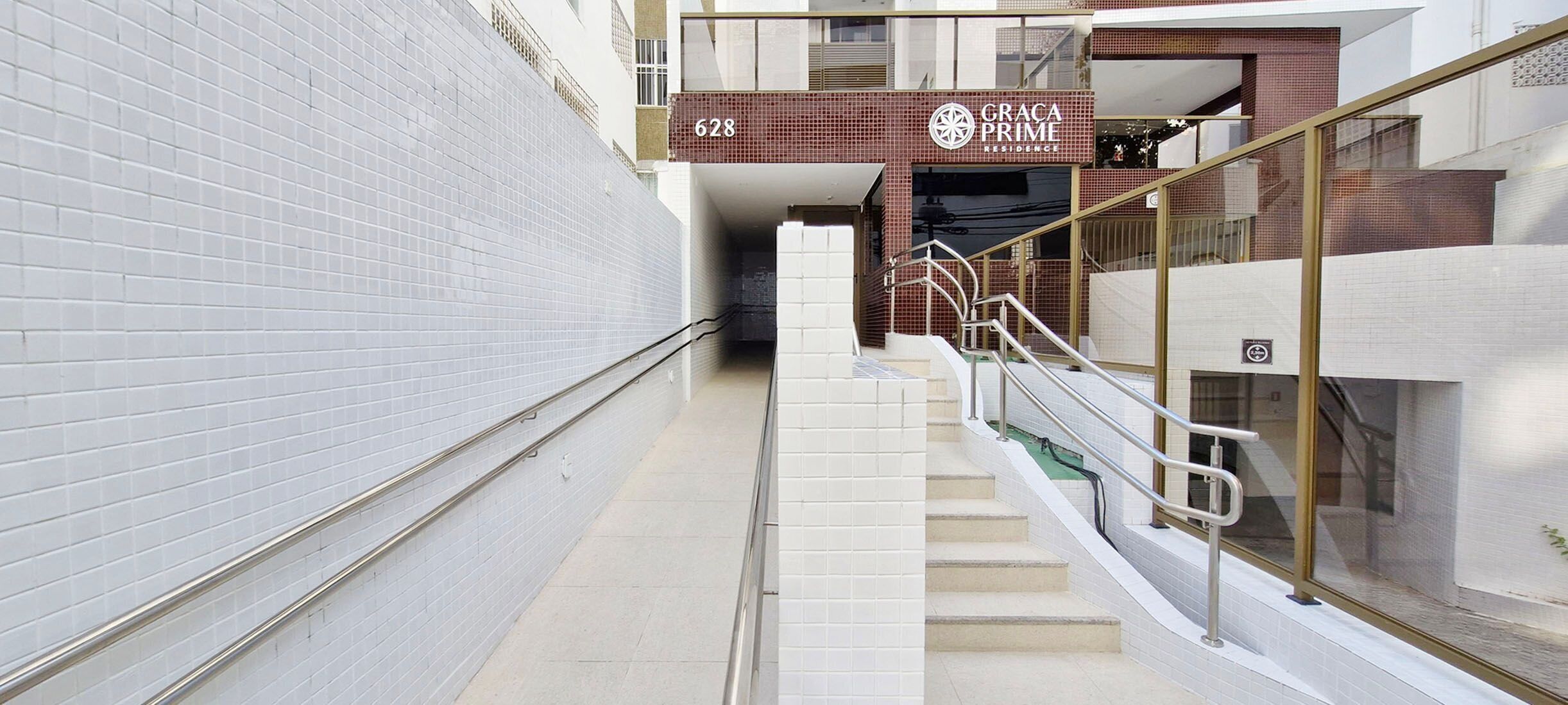 Um edifício moderno com uma escadaria que leva a uma entrada com a placa 