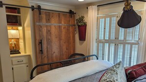 A bedroom with a bed, bedside table, and a hanging plant. - Beautiful 2 Bedroom Apartment Farmhouse in Canton (Canton)