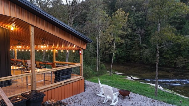 A cabin with a deck overlooking a forested area and a stream. - Amazing Waterfalls & Swim Hole at Dale Hollow Lake (albany)