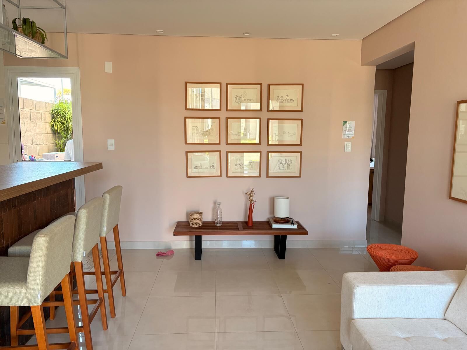 Una sala moderna con comedor, un banco con adornos y obras de arte enmarcadas en la pared.